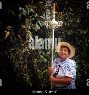 Eine Frau gekleidet wie ein Reaper eine Kerze während Fronleichnam in El Gastor, Sierra de Cadiz, Andalusien, Spanien hält Stockfoto