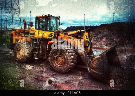 Ein Bagger oder Bulldozer in einer schmutzigen Industrieumgebung, in der Kohle geladen wird. Stockfoto