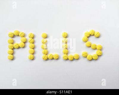 Die Wort-Pillen mit gelben Pillen geschrieben Stockfoto