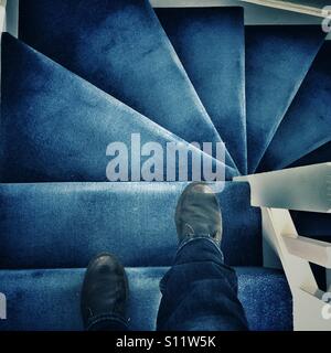 POV. Eine blaue Teppichboden Treppe hinunter. Stockfoto
