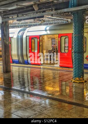 Allein auf dem Schlauch. Whitechapel-Station, mit Licht auf dem Wasser, nach dem Regen etwas beleuchtet. London, Großbritannien Stockfoto