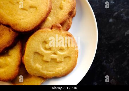 Halloween-Kürbis förmigen Cookies auf einem weißen Teller. Stockfoto