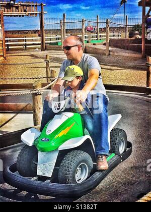 Vater und Sohn fahren ein Autoscooter auf einem Rummelplatz. Stockfoto