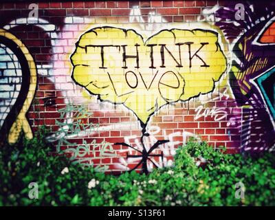 Gelbes glaube Liebe Graffiti Herz auf einer gemauerten Wand in Berlin Kreuzberg Stockfoto