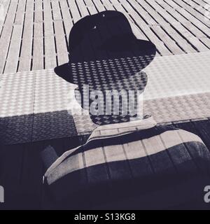 Ein Mann trägt einen Hut Silhouette hinter einem Fenster auf Brighton Pier England UK Stockfoto