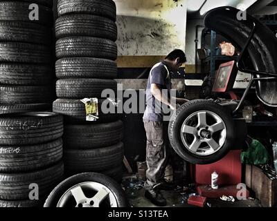 Ein Mechaniker gleicht ein Rad in einem Reifen-Shop in Kuala Lumpur, Malaysia Stockfoto