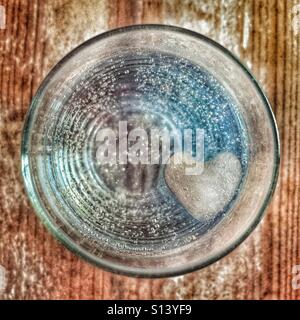 Kaltes Getränk in ein Glas mit einem Eiswürfel in Herzform Stockfoto