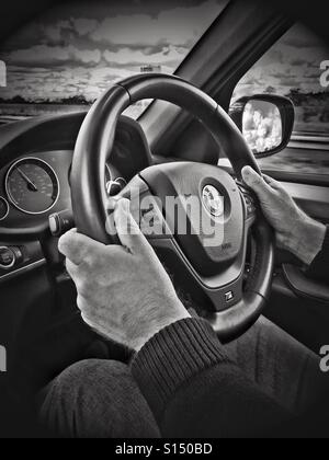Auf dem Fahrersitz. Mann fahren BMW zeigt Hände und Lenkrad. Stockfoto