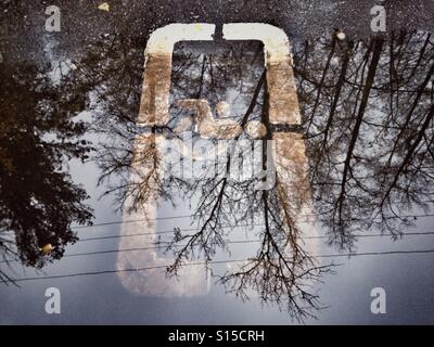 Straße behinderten Parkplatz Schild in einer Pfütze mit Reflexion Stockfoto