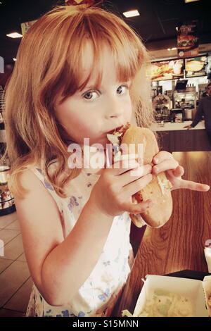 6-jährige Mädchen McDonalds Huhn Legende Burger im Take away Restaurant Essen Stockfoto