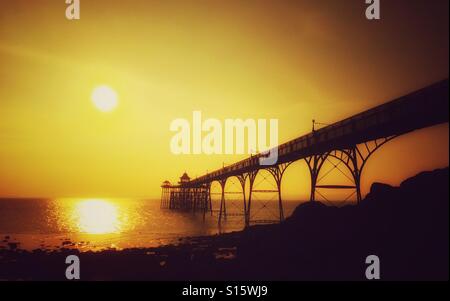 Eine Ansicht beginnt westlich Richtung Wales, Clevedon Pier wie die Sonne zu gründen. Clevedon Pier ist eine Klasse eine aufgeführten Struktur und wurde im viktorianischen Zeitalter erbaut. Bildnachweis - © COLIN HOSKINS. Stockfoto