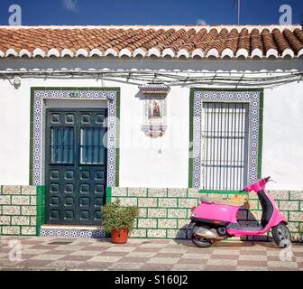 Ein rosa Vespa Motorroller parkten außerhalb eines traditionellen Fischerhaus in Caleta de Vélez, in der Nähe von Málaga, Spanien Stockfoto