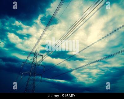 Gecrosst wird Bild von Strommasten gegen einen stürmischen Himmel. Stockfoto