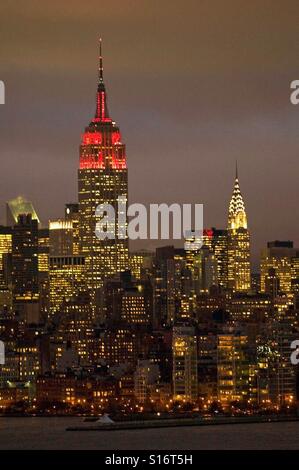 Empire State Building in rote Ampeln für Welt-AIDS-Tag und Chrysler Building. New York City. Stockfoto