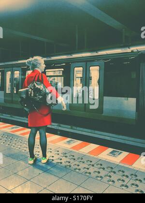 Frau in rot warten in der u-Bahn Stockfoto