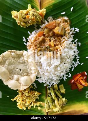 Traditionelle Süd indische mittags Gerichte (Thali) serviert auf einem Bananenblatt, Kerala, Indien Stockfoto