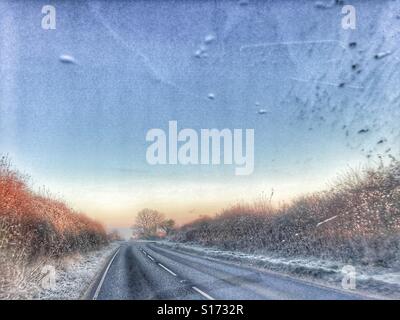 Fahren im Winter. Blick durch die Windschutzscheibe auf einer eisglatten Straße und außergewöhnlich starkem Frost. Stockfoto