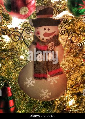 Ein Schneemann aus Holz Ornament an einem Weihnachtsbaum hängen. Stockfoto