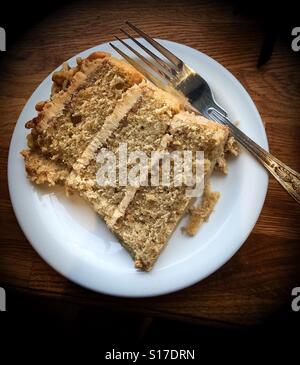 Kaffee und Walnuss Kuchen auf einem runden, weißen Teller mit einer Gabel auf die Seite Stockfoto