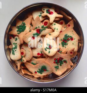 Draufsicht auf eine runde Dose Weihnachtsplätzchen in verschiedenen Formen und Farben Stockfoto