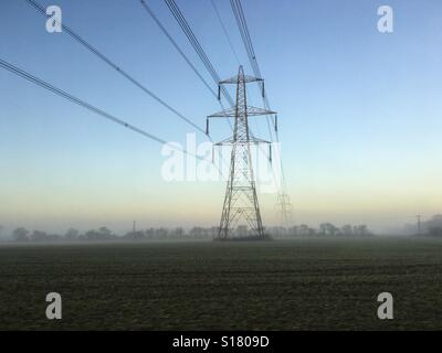 Stromleitungen in den Winter-Nebel in der Abenddämmerung verschwinden Stockfoto