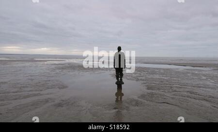 Ein weiterer Ort, Crosby Strand. Einer der Ironmen Antony Gormley. Stockfoto