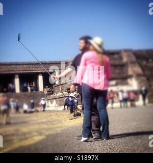 Ein paar fotografieren sich mit einem Handy in einem Stick in Teotihuacan, Mexiko Stockfoto