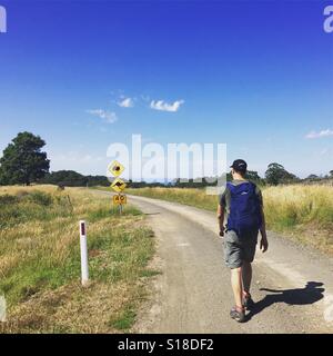 Ein Wanderer geht entlang der Straße auf der Milanesia Strecke entlang der Great Ocean Walk in Süd-West Victoria. Stockfoto