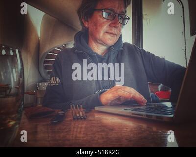 Frau in einem Restaurant, mit ihrem laptop Stockfoto