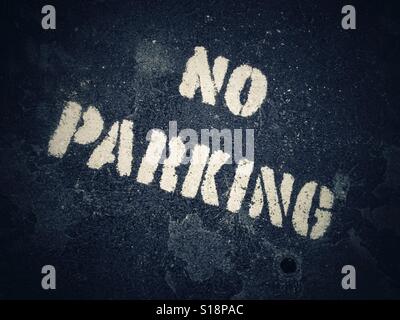 Kein Parkplatz Zeichen Schablone in weißer Farbe auf schwarzem Asphalt Stockfoto