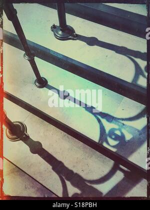 Schmiedeeisen Geländer Schatten auf Treppe Stockfoto