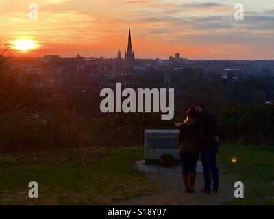 Ein junges Paar genießt Sonnenuntergang Szene mit Blick zur Kathedrale von Norwich, Norfolk, Großbritannien Stockfoto