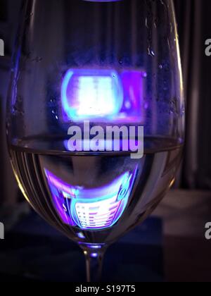 TV durch ein Glas Wein Stockfoto