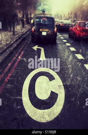 Eine belebte Straße in London mit einem großen City-Maut-Zeichen auf der Straße mit Feierabendverkehr und London Taxis im Stillstand im Stau. Stockfoto