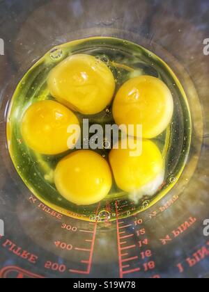 5 rohe Eiern in einem Glasbehälter von oben gesehen Stockfoto