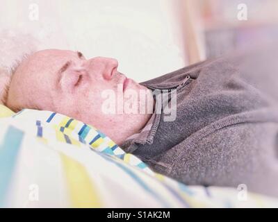 Ein Mann schlief auf einem Bett. Stockfoto