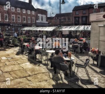 Leute sitzen in einem offenen Luft-Café in der Markt-Stadt Beverley in East Riding of Yorkshire Stockfoto