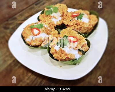 Hor Mok Pla - gedünsteter Fisch in Kokosmilch und Chili-Paste mit Bananenblättern umwickelt Stockfoto
