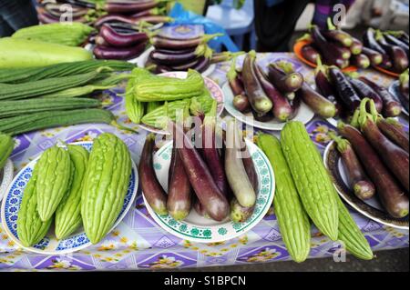 Auberginen zusammen mit Momordica Charantia, bekannt als bittere Melone, Bittermelone, bitterer Kürbis oder Balsambirne, in lokalen Frischmarkt verkauft Stockfoto