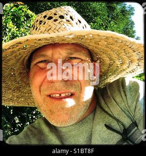 Ein 50 Jahre alter Mann versucht, etwas zu arbeiten. Stockfoto