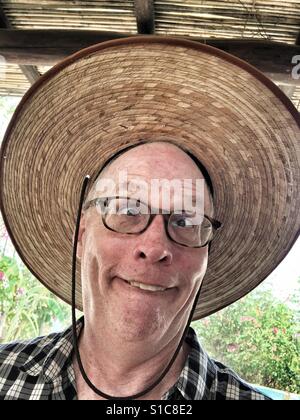 Mann, lustiges Gesicht mit riesigen Hut Stockfoto