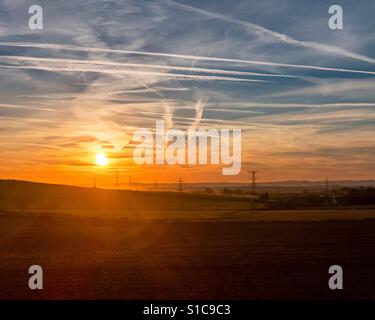 Sonnenuntergang in Kirkby In Ashfield, England mit Strommasten und Äckern. HDR-Bild auf dem iPhone 7 plus. Stockfoto