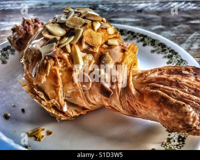 Mandel-Croissant auf einem Teller Stockfoto