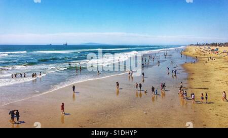 Menschen, die den Strand an einem sonnigen blauen Himmel Tag genießen. 16 x 9 Stockfoto