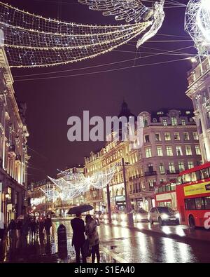 Einem regnerischen Regent Street beleuchtet mit Weihnachtsbeleuchtung Stockfoto