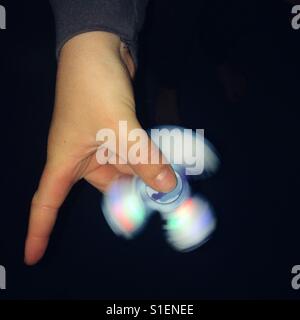 Junge spielt mit einem led Fidget spinner Stockfoto