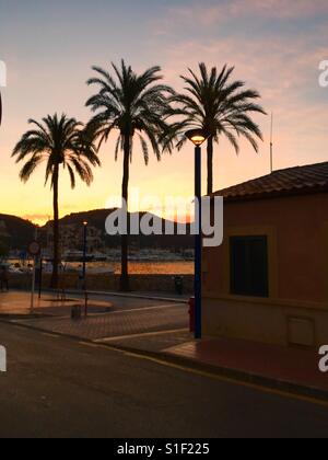 Palmen, Haus, Straße. Meer und die Berge im Sonnenuntergang Stockfoto