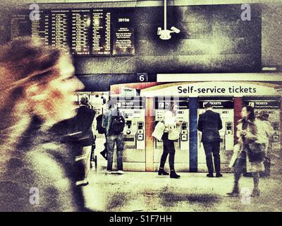 Self Service-Tickets Automaten, Abfahrtszeiten und Pendler in der Rush Hour. Bahnhof Waterloo, London, England. Stockfoto