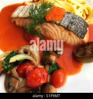Gegrilltes Lachssteak mit Nudeln und Gemüse serviert Stockfoto