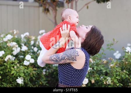 Hippe junge Mutter mit Baby Mädchen Tochter hielt tattoos Stockfoto